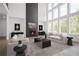 Bright living room features a modern fireplace and large windows showcasing a serene, wooded view at 6745 Dahlgren Ct, Cumming, GA 30028