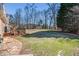 Large, grassy backyard with mature trees, offering ample space for recreation and relaxation at 5545 Woodsong Trl, Dunwoody, GA 30338