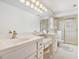 Bright bathroom featuring double sink vanity, and enclosed shower with gold trim at 5545 Woodsong Trl, Dunwoody, GA 30338