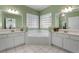 Elegant bathroom with double vanities, a corner soaking tub, and large windows at 164 Castlewood Rd, Tyrone, GA 30290