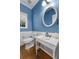 Charming powder room with pedestal sink and a unique oval mirror at 164 Castlewood Rd, Tyrone, GA 30290