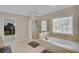 Bright bathroom featuring a large soaking tub, glass enclosed shower and large window at 2025 Fife Ridge Ct, Roswell, GA 30075