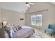 Comfortable bedroom featuring a large window, chair, and bed with soft, neutral-toned bedding and an attached tv mount at 2025 Fife Ridge Ct, Roswell, GA 30075