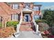 Inviting front entrance with brick steps, a white railed staircase and landscaped bushes and flowerbeds at 2025 Fife Ridge Ct, Roswell, GA 30075