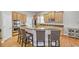 Spacious kitchen featuring stainless steel appliances, a breakfast bar, and hardwood floors at 2025 Fife Ridge Ct, Roswell, GA 30075