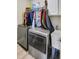 Modern laundry room with stainless steel washer and dryer, a utility sink, and ample storage space at 2025 Fife Ridge Ct, Roswell, GA 30075