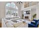 Bright living room with a fireplace, comfortable seating, and a large window overlooking the yard at 2025 Fife Ridge Ct, Roswell, GA 30075