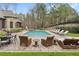 This backyard features a refreshing pool and a stone patio with plenty of seating and lounge chairs at 918 Big Horn Holw, Suwanee, GA 30024