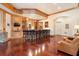 Entertainer's bar with dark hardwood floors, custom cabinetry, and bar seating, creating a perfect spot for socializing at 918 Big Horn Holw, Suwanee, GA 30024