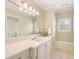 Clean, neutral bathroom featuring white cabinets, drawers, a large mirror, and a window with great natural light at 918 Big Horn Holw, Suwanee, GA 30024