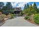 Charming home exterior with stone accents, a golf cart, lush landscaping, and a winding driveway at 918 Big Horn Holw, Suwanee, GA 30024