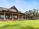 Expansive home exterior featuring covered patios, stone accents, and lush lawn at 918 Big Horn Holw, Suwanee, GA 30024