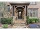 Elegant stone entryway with wrought iron door and manicured landscaping at 918 Big Horn Holw, Suwanee, GA 30024