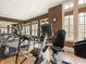Well-equipped home gym with exercise machines, mirrors, and natural light for fitness activities at 918 Big Horn Holw, Suwanee, GA 30024