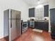 Well-equipped kitchenette with stainless steel appliances, dark cabinets, and wood flooring at 918 Big Horn Holw, Suwanee, GA 30024