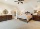 Spacious main bedroom featuring soft carpet, wooden furniture, and a neutral palette, creating a serene and comfortable retreat at 918 Big Horn Holw, Suwanee, GA 30024