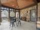 Covered outdoor patio with stone wall, ceiling fan, and outdoor dining set, creating a cozy and inviting space at 918 Big Horn Holw, Suwanee, GA 30024