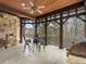 Covered patio with a stone wall, ceiling fan, and outdoor furniture, perfect for dining and relaxing in comfort at 918 Big Horn Holw, Suwanee, GA 30024