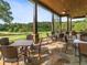 Inviting covered patio with stone flooring, ceiling fans, and views of the lush golf course at 918 Big Horn Holw, Suwanee, GA 30024