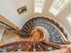 Intricate spiral staircase with wooden handrail, detailed carpet runner, and skylights, showcasing architectural elegance and design at 918 Big Horn Holw, Suwanee, GA 30024