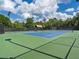 Well-maintained tennis court on a sunny day with a covered bench at 918 Big Horn Holw, Suwanee, GA 30024
