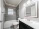 Updated bathroom with gray tile, vanity, and bathtub at 3693 Aldea Dr, Decatur, GA 30032