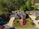 Overhead view of a brick home with mature trees, lush landscaping, and a curved driveway at 701 Vinings Estates Se Dr, Smyrna, GA 30126