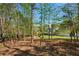 View of the backyard showing the trees and the back of the house from a distance at 701 Vinings Estates Se Dr, Smyrna, GA 30126