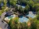 Aerial view of community pool and tennis courts nestled amongst lush trees at 701 Vinings Estates Se Dr, Smyrna, GA 30126
