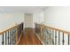 Hallway with wooden floors and an ornate black and wood railing at 701 Vinings Estates Se Dr, Smyrna, GA 30126