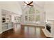 Living room with hardwood floors, a fireplace, a ceiling fan, and large windows with outdoor views at 701 Vinings Estates Se Dr, Smyrna, GA 30126