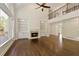 Living room featuring hardwood floors, a fireplace with built-ins, a ceiling fan, and windows with outdoor views at 701 Vinings Estates Se Dr, Smyrna, GA 30126
