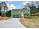 Newly built green house with a two-car garage and a landscaped yard at 153 Oak St, Hiram, GA 30141