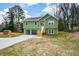 Green house with attached garage and wooden stairs leading to the front entrance at 153 Oak St, Hiram, GA 30141