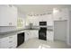 Modern kitchen with white cabinets, granite countertops, and black appliances at 153 Oak St, Hiram, GA 30141