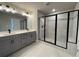 This bathroom boasts a double sink vanity with a glass-enclosed shower with black trim at 391 Lincoln St, Woodstock, GA 30188