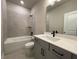 Modern bathroom with a combined bathtub and shower, gray vanity, and neutral tile work at 391 Lincoln St, Woodstock, GA 30188