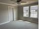 A well lit bedroom features carpet, a ceiling fan, and natural light at 391 Lincoln St, Woodstock, GA 30188