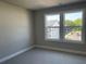This bedroom features plush carpet and an abundance of natural light from the double windows at 391 Lincoln St, Woodstock, GA 30188