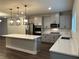 Modern kitchen with quartz countertops, gray cabinets, stainless steel appliances, and pendant lighting at 391 Lincoln St, Woodstock, GA 30188
