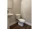 This powder room features a pedestal sink, a modern faucet, and a toilet with a white finish at 391 Lincoln St, Woodstock, GA 30188