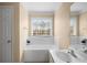 Bathroom with bathtub, window, and single sink vanity at 3111 Green Gate Se Way, Conyers, GA 30013