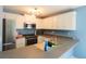 Kitchen boasts white cabinets, stainless steel appliances and granite countertops at 8045 Woodlake Dr, Riverdale, GA 30274