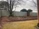 Landscaped backyard with a wooden fence and brick wall at 1142 Drewsbury Se Ct, Smyrna, GA 30080