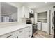 Modern kitchen with stainless steel appliances, white cabinets, and laundry area at 1608 Vicksburg Pl, Sandy Springs, GA 30350