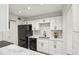 Modern kitchen with white cabinets, sleek black appliances, and stylish backsplash at 1608 Vicksburg Pl, Sandy Springs, GA 30350