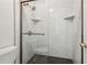 Modern glass-enclosed shower with tiled walls and a unique floor design for a spa-like experience at 1608 Vicksburg Pl, Sandy Springs, GA 30350