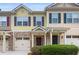 Tan and yellow townhome with stone accents, two-car garage, and landscaping at 4940 Parke Brook Dr, Acworth, GA 30101