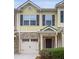 Two story townhome with yellow siding, stone accents, and a two car garage at 4940 Parke Brook Dr, Acworth, GA 30101