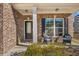 Inviting front porch with brick columns, two wicker chairs, and landscaping at 210 Omega Ct, Dallas, GA 30157